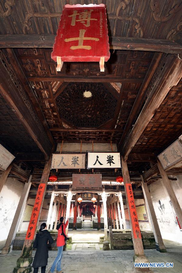 Tourists visit an ancient building in Tianbao Village in Yifeng County, east China's Jiangxi Province, Jan. 30, 2013. Tianbao Village, whose history is about 1,800 years, can date back to the Tang Dynasty (618-907), covering an area of more than 2.5 square kilometers. Tianbao was ever the county site of the ancient Yifeng County, carrying profound cultural connotation. There are more than 120 buildings in the village built in the Ming and Qing dynasties (1368-1912), all of which present high artistic value. The village has been listed in the pool of national cultural and natural heritage protection projects. (Xinhua/Song Zhenping)