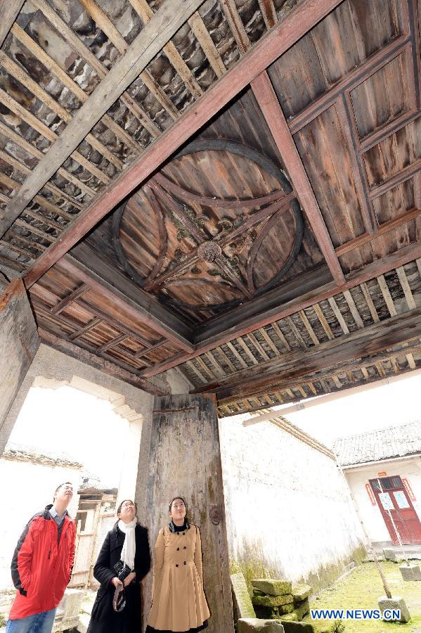 Tourists visit an ancient building in Tianbao Village in Yifeng County, east China's Jiangxi Province, Jan. 30, 2013. Tianbao Village, whose history is about 1,800 years, can date back to the Tang Dynasty (618-907), covering an area of more than 2.5 square kilometers. Tianbao was ever the county site of the ancient Yifeng County, carrying profound cultural connotation. There are more than 120 buildings in the village built in the Ming and Qing dynasties (1368-1912), all of which present high artistic value. The village has been listed in the pool of national cultural and natural heritage protection projects. (Xinhua/Song Zhenping)