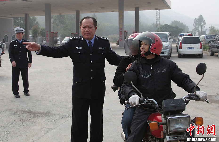 A local policeman guides the homecoming migrant workers to have a rest at a highway toll station in south China's Guangdong province, Jan. 30. On Wednesday, about 5,000 motorbikes taking migrant workers home from Guangdong run into the neighboring Guangxi Zhuang Autonomous Region for the upcoming Spring Festival. Traffic police said about 3,000 such bikes passed through the county every day thanks to the well-developed roads connecting Guangxi and Guangdong. Local government offered free services including police escort, food, beverage and medical care to these homecoming people on the motorbike. (Photo/Chinanews.com)