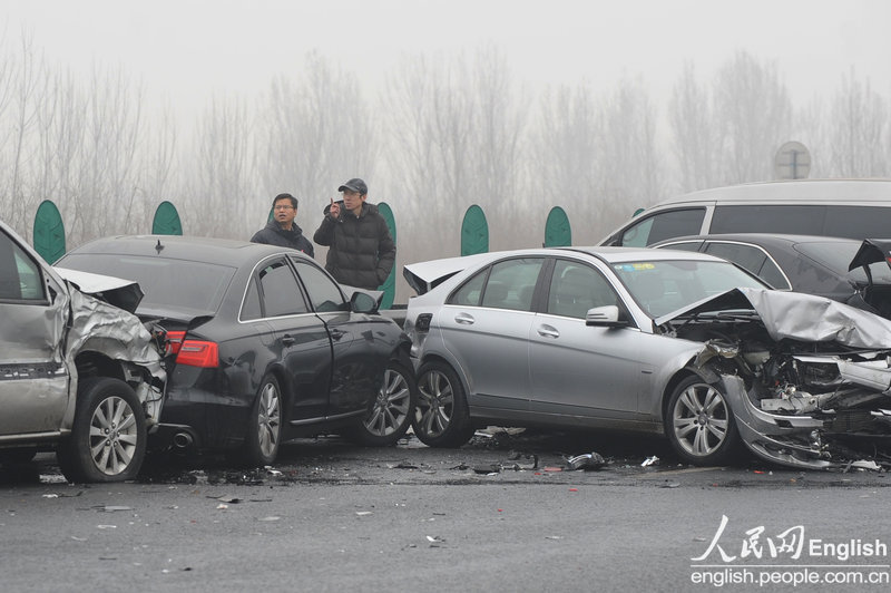 Rain and light snow falls in Beijing slightly disperse the lingering smog that suffocated the city for a few days. A fresh cold front hit the central and eastern China on Thursday and was expected to ease the smog that suffocated these areas in the past few days. Because of the freezing temperature, the rainwater turned to thin ice on the road, leading to many slips and traffic accidents in Beijing on Thursday. (Photo/CFP)