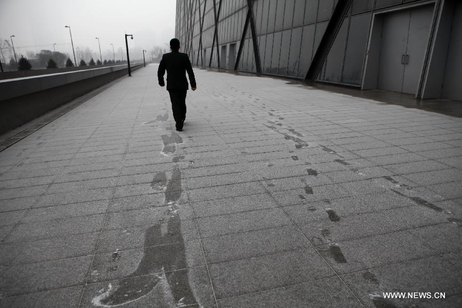 A man walks on a snow-covered pathway in Beijing, capital of China, Jan. 31, 2013. Light snow hit parts of the city on Thursday and the local meteorological observatory issued a yellow alert for icy road. (Xinhua/Jin Liwang) 