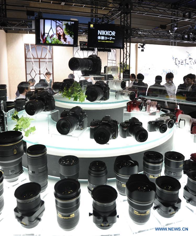 Visitors pass by the Nikon booth during the CP plus Camera and Photo Imaging Show 2013 in Yokohama, Japan, Jan. 31, 2013. Around 96 companies are participating in the exhibition. (Xinhua/Kenichiro Seki)