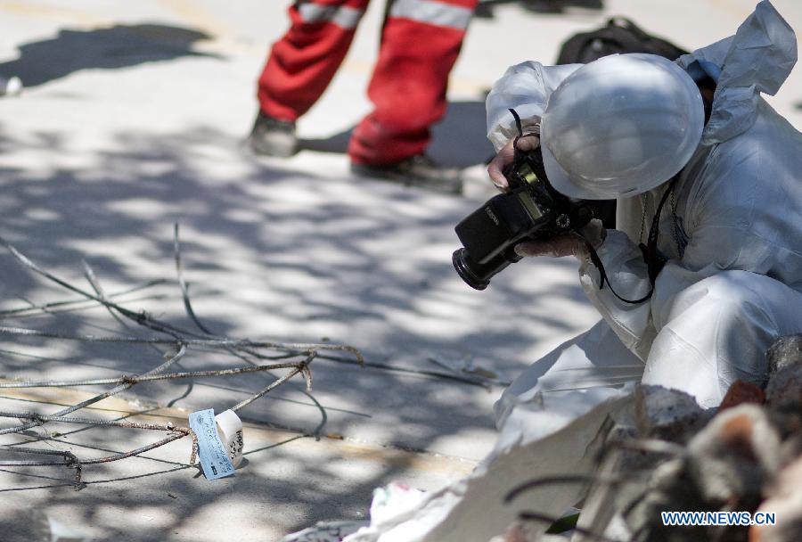 An expert takes photos of debris at the site of an explosion at the headquarters of Mexico's oil giant PEMEX, in Mexico City, capital of Mexico, on Feb. 2, 2013. Mexican and American experts carried out the research on reasons of the powerful explosion at the building E-B2 of the headquarters of Mexican oil giant Pemex, which caused the death of 33 people, injuring 121 others. (Xinhua/Shi Sisi)