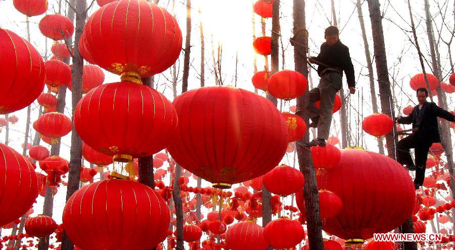 Villagers hang red lanterns on the trees in Zhengzhou, capital of central China's Henan Province, Jan. 27, 2006. People living in the central China region has a tradition to hang red lanterns, which symbolizes prosperous and auspicious life. Chinese people who live in the central China region have formed various traditions to celebrate the Chinese Lunar New Year. (Xinhua/Wang Song)