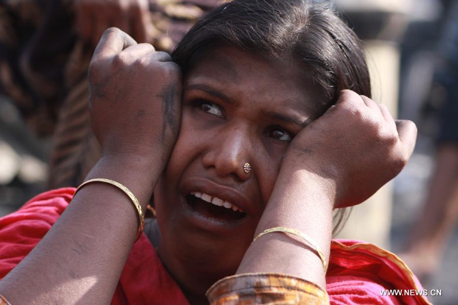 A woman reacts after a fire accident destroyed her house in a slum in Dhaka, Bangladesh, Feb. 3, 2013. About 100 shanties were destroyed in the accident, official said. (Xinhua/Shariful Islam)