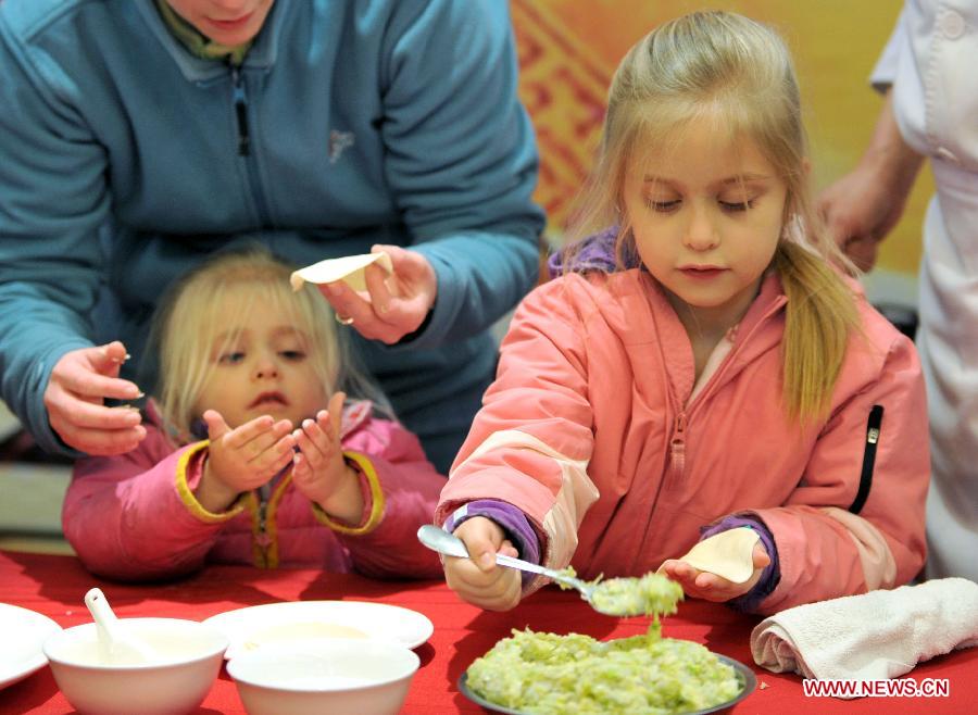 Children of an overseas student learn to make dumplings in an activity to celebrate the Chinese New Year at the Nanjing Agricultural University in Nanjing, capital of east China's Jiangsu Province, Feb. 4, 2013. More than 50 overseas students from over 20 countries and regions experienced Chinese traditional cultural activities with local students. (Xinhua) 