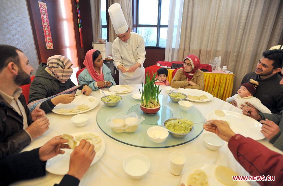 A chef teaches overseas students to make dumplings in an activity to celebrate the Chinese New Year at the Nanjing Agricultural University in Nanjing, capital of east China's Jiangsu Province, Feb. 4, 2013. More than 50 overseas students from over 20 countries and regions experienced Chinese traditional cultural activities with local students. (Xinhua)  