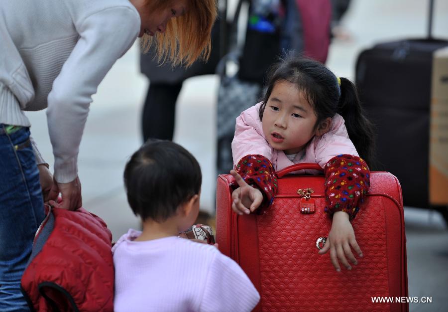 A girl talks to her younger brother at Nanning train station in Nanning, capital of south China's Guangxi Zhuang Autonomous Region, Feb. 3, 2013. Many children travel with their families during the 40-day Spring Festival travel rush which started on Jan. 26. The Spring Festival, which falls on Feb. 10 this year, is traditionally the most important holiday of the Chinese people. Public transportation is expected to accommodate about 3.41 billion trips nationwide during the holiday, including 225 million trips by railways. (Photo/Xinhua)