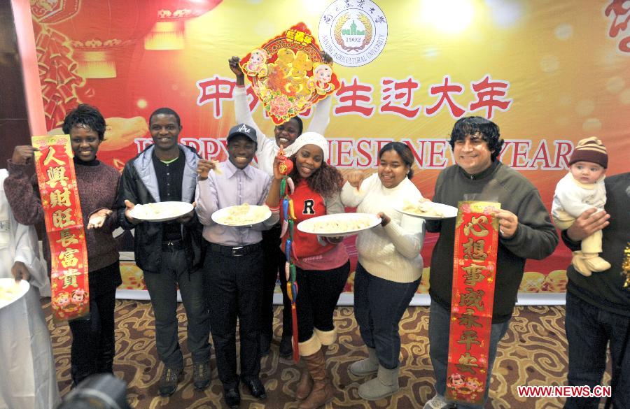 Overseas students present dumplings they made in an activity to celebrate the Chinese New Year at the Nanjing Agricultural University in Nanjing, capital of east China's Jiangsu Province, Feb. 4, 2013. More than 50 overseas students from over 20 countries and regions experienced Chinese traditional cultural activities with local students. (Xinhua) 