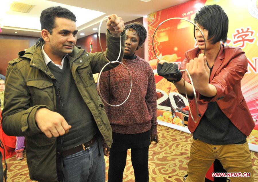 Overseas students learn tricks of magic in an activity to celebrate the Chinese New Year at the Nanjing Agricultural University in Nanjing, capital of east China's Jiangsu Province, Feb. 4, 2013. More than 50 overseas students from over 20 countries and regions experienced Chinese traditional cultural activities with local students. (Xinhua)  