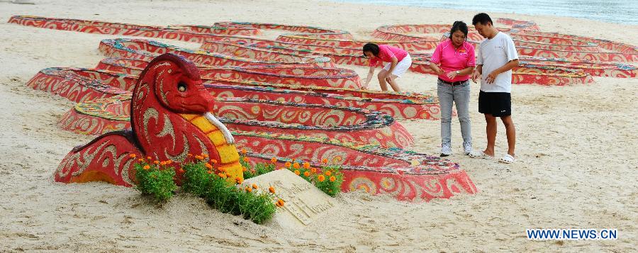 Workers create the snake sand statue on the Sentosa Island, Singapore, Feb. 4, 2013. The flower show on the Sentosa Island to celebrate the Spring Festival opens from Feb. 9 to 17. (Xinhua/Then Chih Wey) 