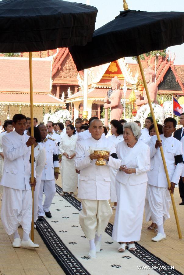 Cambodian King Norodom Sihamoni holds up a golden urn of late King Father Norodom Sihanouk's ashes at a cremation site next to the royal palace in Phnom Penh, capital of Cambodia, on Feb. 5, 2013. Cambodian royal families brought late King Father Norodom Sihanouk's ashes to scatter at the confluence of four rivers in front of the capital city's royal palace on Tuesday after his body was cremated. (Xinhua/Sovannara)