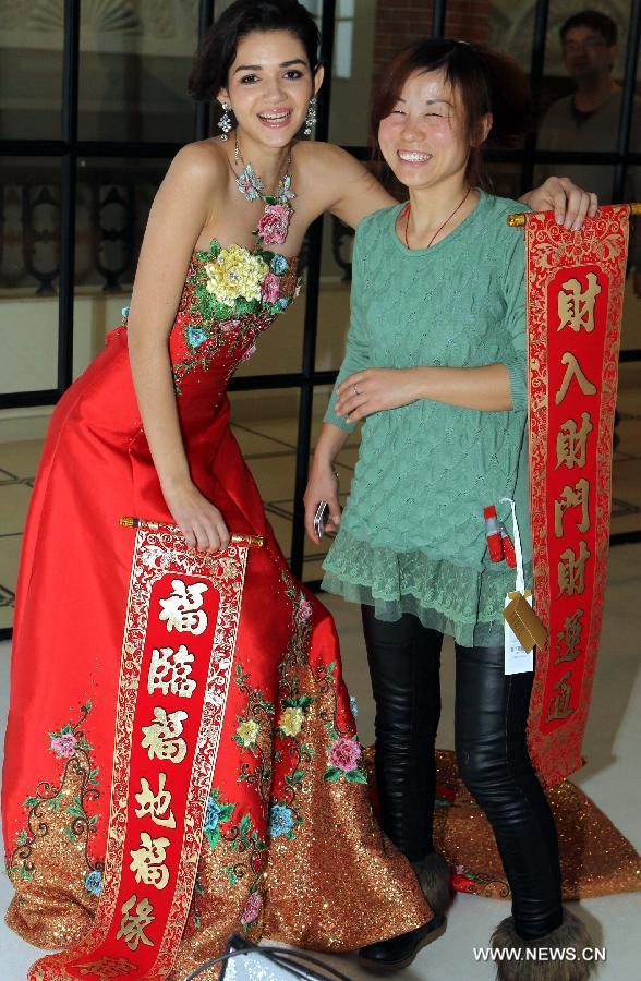 A model in a tailor-made wedding dress poses with a fan during a show on the Bund in Shanghai, east China, Feb. 5, 2012. (Xinhua/Zhang Ming)