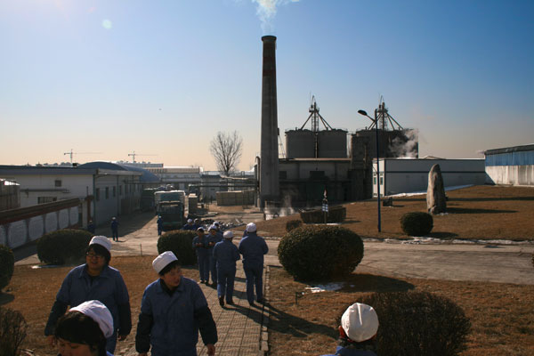 A smokestack releases plumes of steam as workers at the Erguotou baijiu factory in Beijing go about their business. (CRIENGLISH.com/William Wang)