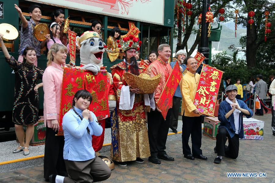 Working staff send the New Year greetings to visitors in the newly-renovated Hong Kong Ocean Park in south China's Hong Kong, Feb. 5, 2013. The 2013 Lunar Lucky Fiesta will be held from Feb. 9 to 24 in the ocean park to celebrate the coming Chinese New Year of the Snake. (Xinhua/Li Peng)