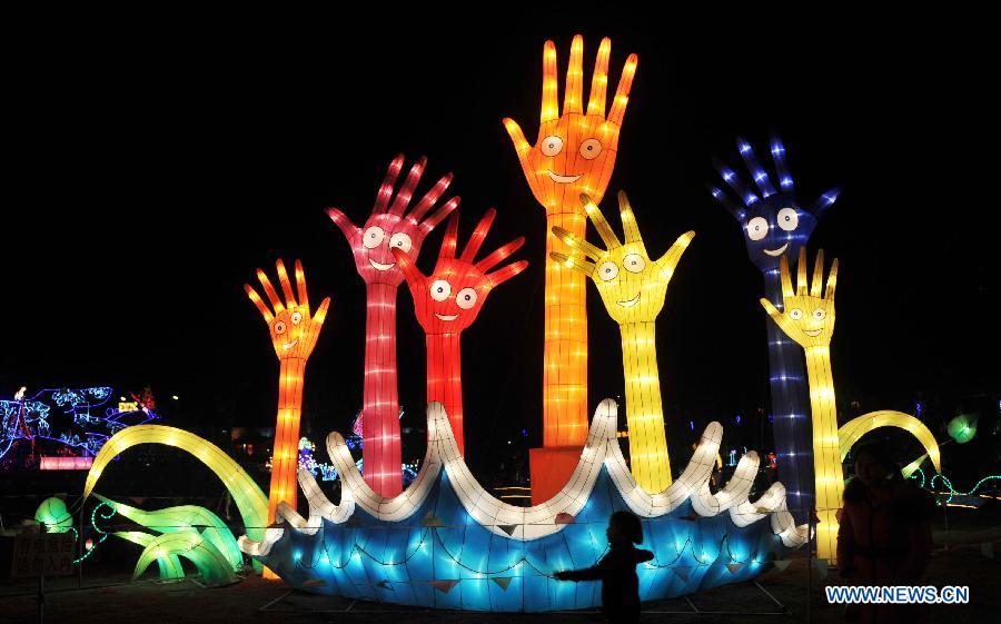 A young girl views festive lanterns during a lantern show in Changsha, capital of central China's Hunan Province, Feb. 5, 2013. The lantern show was held to greet the upcoming Spring Festival, or the Chinese Lunar New Year, which falls on Feb. 10 this year. (Xinhua/Li Ga)