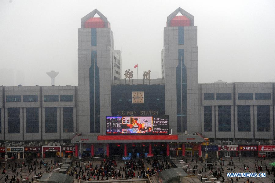 Passengers are seen in front of the Zhengzhou Railway Station in Zhengzhou, capital of central China's Henan Province, Feb. 6, 2013. China's transport system sees an annual travel rush around the Spring Festival, which starts on Feb. 10 this year. (Xinhua/Li Bo)