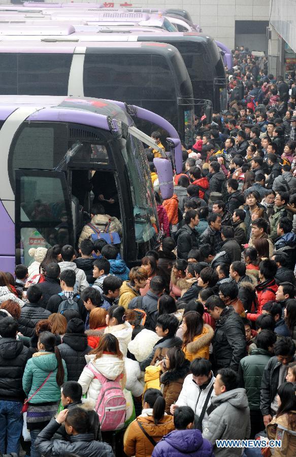 Passengers take buses in a coach hub in Zhengzhou, capital of central China's Henan Province, Feb. 6, 2013. China's transport system sees an annual travel rush around the Spring Festival, which starts on Feb. 10 this year. (Xinhua/Li Bo)