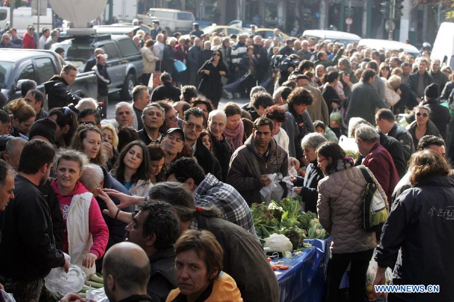 People queue for a free distribution of fruits and vegetables from the farmers outside Greece's Agriculture Ministry in Athens, Greece, on Feb 6, 2013. Greek farmers continued on Wednesday their 10-day protests against tax hikes while distributing tons of vegetables and fruits for free to needy citizens. (Xinhua/Marios Lolos)