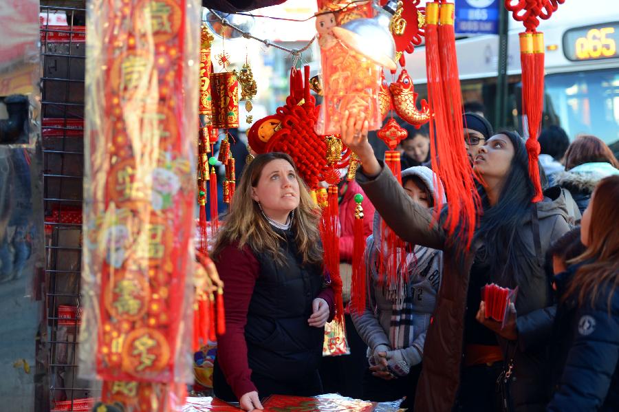 Local residents look at the traditional decorations for the upcoming Chinese Lunar New Year in China Town, New York, the United States, Feb. 6, 2013. The Chinese Lunar New Year, or Spring Festival, starts on Feb. 10 this year. (Xinhua/Wang Lei) 