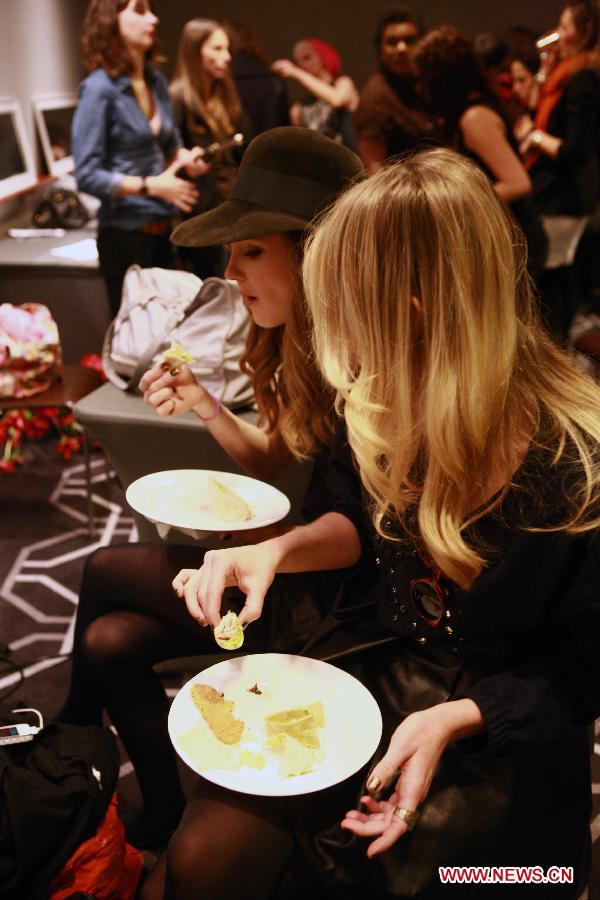 Models eat snacks during the backstage section prior to the WHIT Fall 2013 collection, at the W Hotel in Manhattan of New York, the United States, Feb. 6, 2013. The WHIT Fall 2013 collection, inspired by romantic movements and themes, emphasizes a young dreamy Marianne Faithful. Following a bright Spring Collection, the Fall Collection settles on a darker palate with fresh plays on plaids, paisleys, and animal print. (Xinhua/Zhai Xi)