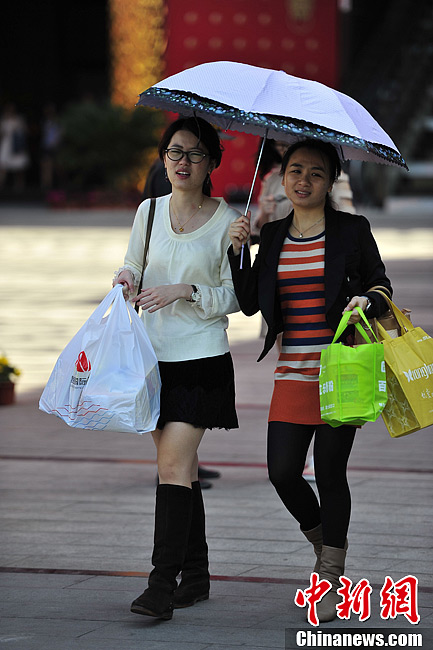 People go out in summer dress in Hainan on Feb. 6, 2013. The temperature of Hainan province rose to 30 degrees Celsius. People and travelers felt a different hot winter here. (Photo/Chinanews)