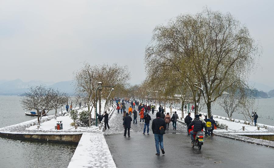 Tourists wonder by the West Lake after a snowfall in Hangzhou, capital of east China's Zhejiang Province, Feb. 8, 2013. A big range of snowfall enveloped Zhejiang Province on Friday. (Xinhua/Xu Yu) 