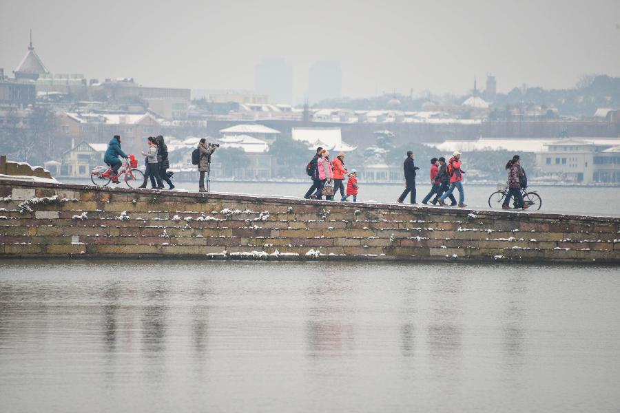 Tourists visit the West Lake after a snowfall in Hangzhou, capital of east China's Zhejiang Province, Feb. 8, 2013. A big range of snowfall enveloped Zhejiang Province on Friday. (Xinhua/Xu Yu) 