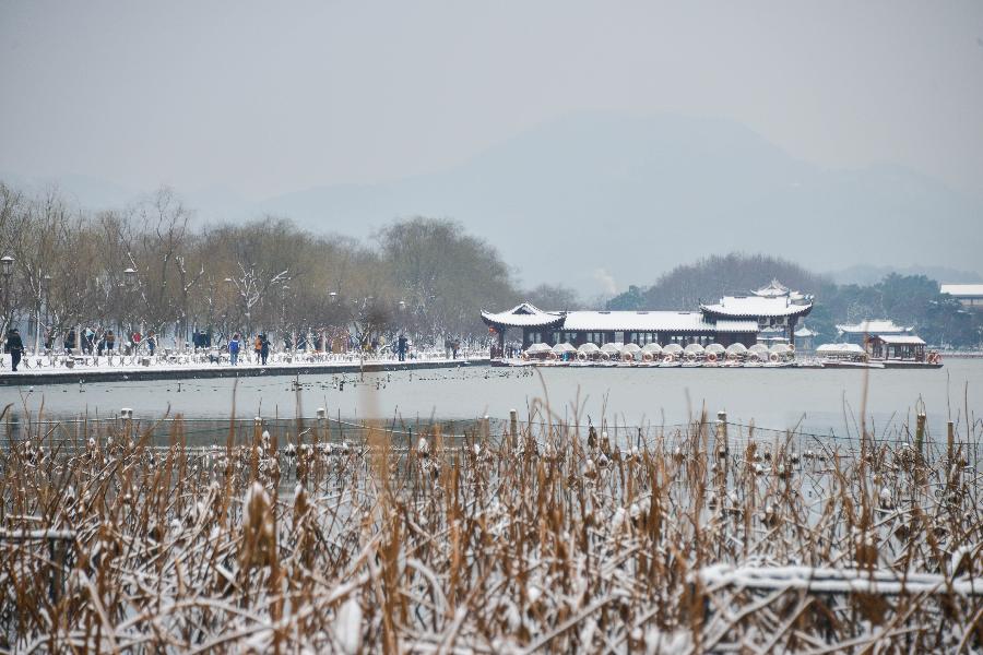 Tourists wonder by the West Lake after a snowfall in Hangzhou, capital of east China's Zhejiang Province, Feb. 8, 2013. A big range of snowfall enveloped Zhejiang Province on Friday. (Xinhua/Xu Yu) 