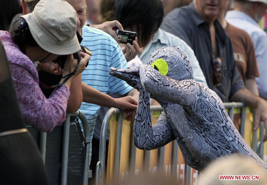 A performer dressed as snake interacts with residents at a ceremony held by Sydney City Council to start a series of events celebrating Chinese Lunar New Year at China Town in Sydney, Australia, Feb. 8, 2013. (Xinhua/Jin Linpeng) 