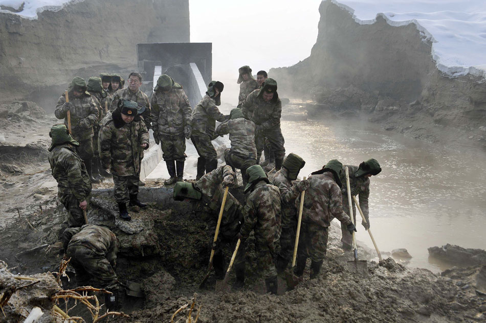 Militiamen make urgent repair on a breached dyke of the Lianfeng Reservoir in Urumqi, Feb. 2. The reservoir leak left one dead and more than a dozen injured. (Xinhua/Zhao Ge)