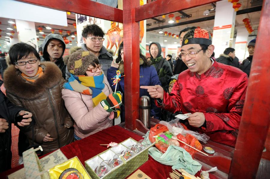 A lady (C) buys a clay figurine at a temple fair celebrating Chinese Lunar New Year, or the Spring Festival, in Shenyang, capital of northeast China's Liaoning Province, Feb. 10, 2013. Various activities were held all over China on Sunday to celebrate the Spring Festival, marking the start of Chinese lunar Year of the snake. The Spring Festival falls on Feb. 10 this year. (Xinhua/Yang Xinyue) 