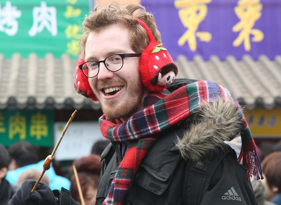 A foreigner tastes special snacks at a templ fair held to celebrate Chinese Lunar New Year, or Spring Festival, in the Ditan Park, Beijing, capital of China, Feb. 10, 2013. Various activities were held all over China on Sunday to celebrate the Spring Festival, marking the start of Chinese lunar Year of the snake. The Spring Festival falls on Feb. 10 this year. (Xinhua/Liang Zhiqiang) 