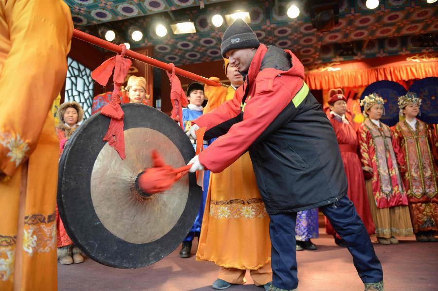 A representative of Beijing sanitation workers knocks a bell to inaugurate the 18th Honglou Temple Fair held at the Grand View Garden in Beijing, capital of China, Feb. 10, 2013. Various activities were held all over China on Sunday to celebrate the Spring Festival, marking the start of Chinese lunar Year of the snake. The Spring Festival falls on Feb. 10 this year. (Xinhua/Zheng Yong) 