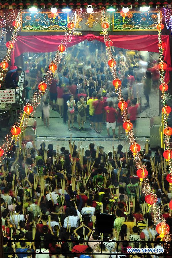Overseas Chinese pray for good fortune at a temple along Waterloo Street in Singapore on the eve of the Lunar New Year on Feb. 9, 2013. (Xinhua/Then Chih Wey) 