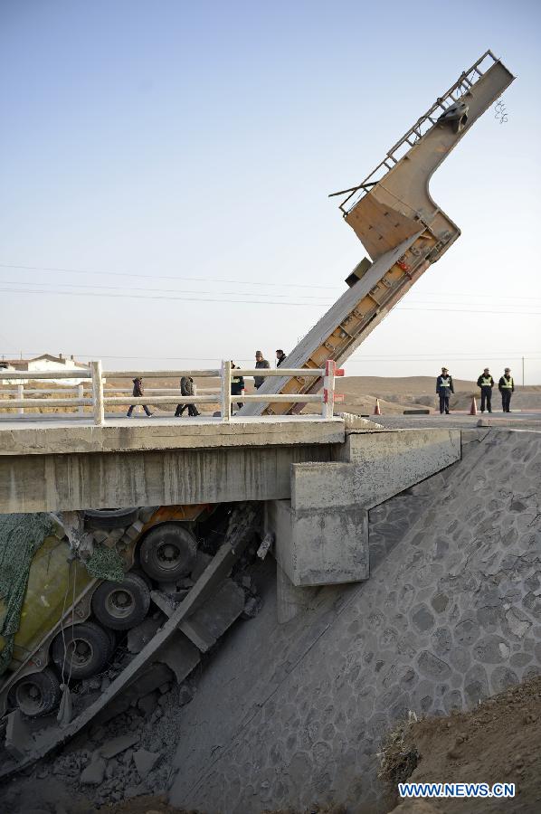 Photo taken on Feb. 10, 2013 shows an outsized casting and its cargo trailer falling down a bridge on No. 304 Provincial Highway, the Shuitao Village, Hongsibao District of Wuzhong City, northwest China's Ningxia Hui Autonomous Region. According to local highway authorities, an overloaded truck carrying the outsized casting, with a gross weight of 100 tons, crushed the bridge with design load of only 55 tons when the truck tried to pass over it. (Xinhua/Wang Peng) 