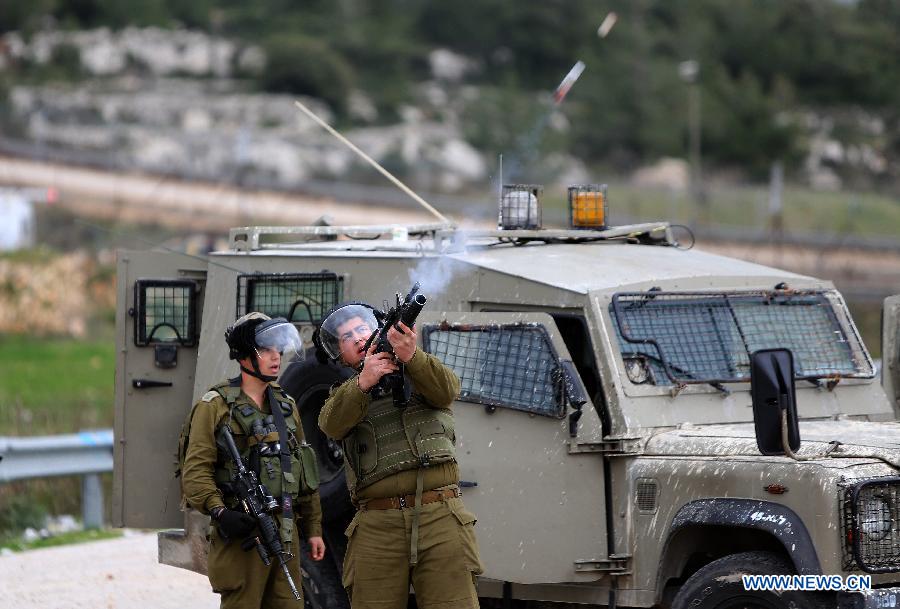 Israeli soldiers fire at Palestinian protestors outside Ofer Prison near the West Bank city of Ramallah on Feb.12, 2013. Five protestors supporting Palestinian prisoners were reported injured during the clashes. (Xinhua/Fadi Arouri) 