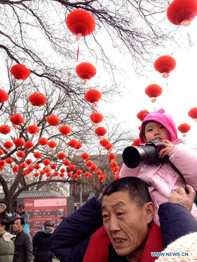 A man carrying his child is seen at a temple fair held to celebrate the Spring Festival, or the Chinese Lunar New Year, in Beijing, capital of China, Feb. 10, 2013. (Xinhua/He Guang)