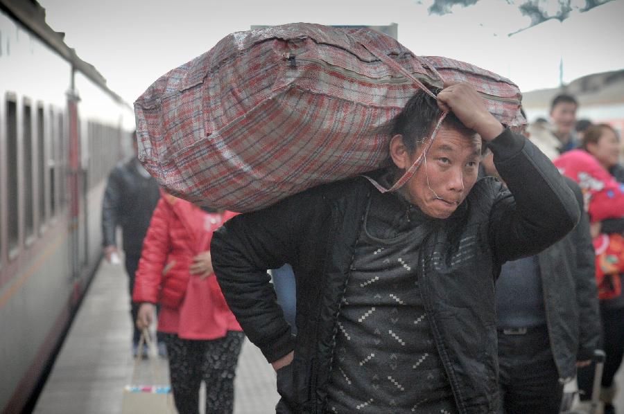 A man carries his bag walking on the platform in a train station in Fuyang of east China's Anhui Province, Feb. 13, 2013. Some people in China started the return trips to their workplaces as the Spring Festival holiday coming to its conclusion. (Xinhua/Guo Chen)