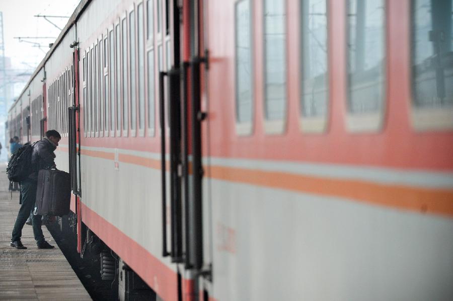 A passenger gets onto a train in Fuyang of east China's Anhui Province, Feb. 13, 2013. Some people in China started the return trips to their workplaces as the Spring Festival holiday coming to its conclusion. (Xinhua/Guo Chen) 