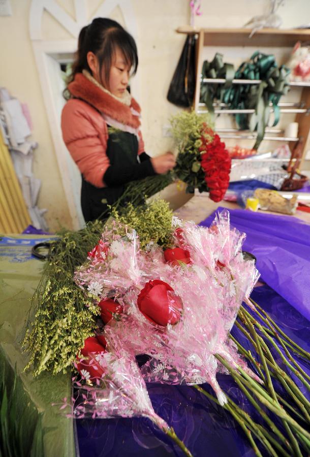 A woman works on a bunch of roses in a flower shop in Yinchuan, capital of northwest China's Ningxia Hui Autonomous Region, Feb. 13, 2013. Florists in Yinchuan began their preparation of bouquets for the upcoming Valentine's Day. (Xinhua/Peng Zhaozhi) 