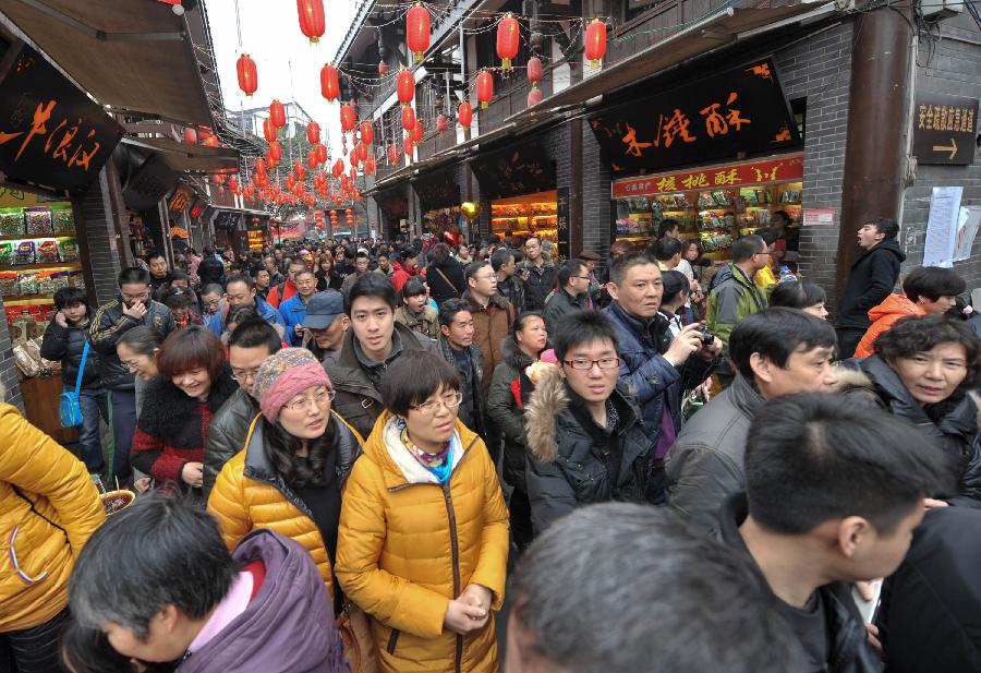 Tourists are seen on a street of the Ciqikou Town in southwest China's Chongqing Municipality, Feb. 13, 2013. Large amount of tourists visited the time-honored Ciqikou during the Spring Festival holiday. (Xinhua/Liu Chan) 