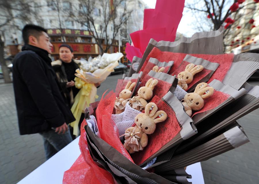 A bunch of bunny dolls in the shape of bouquet is seen at a flower stall on a street in Yinchuan, capital of northwest China's Ningxia Hui Autonomous Region, Feb. 13, 2013. Florists in Yinchuan began their preparation of bouquets for the upcoming Valentine's Day. [Xinhua/Peng Zhaozhi]
