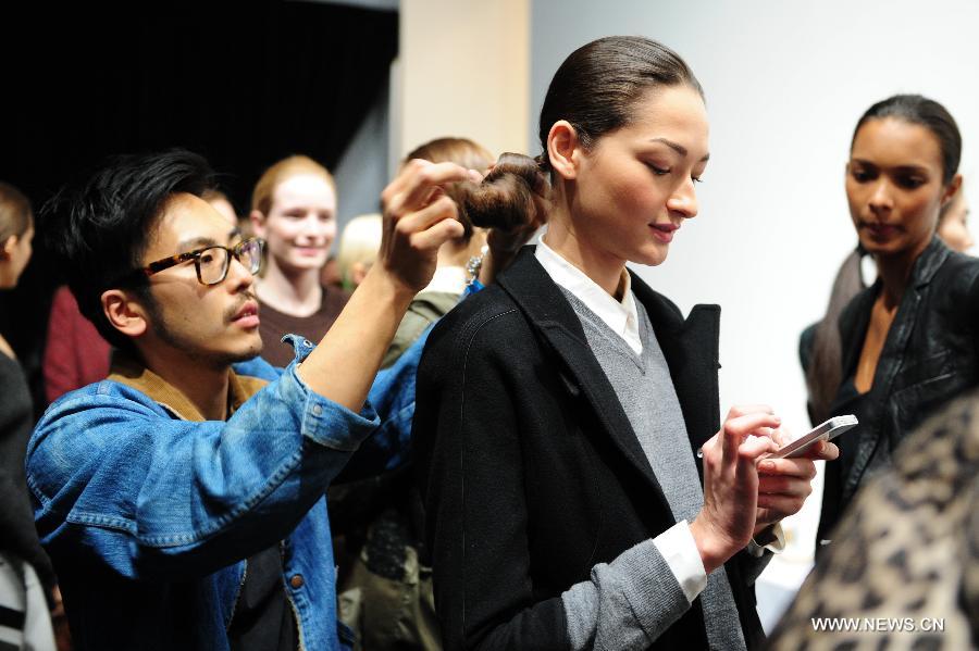 A stylist makes hair for a model at the backstage before the presentation of Ralph Lauren 2013 Fall collections of the Mercedes-Benz Fashion Week in New York, Feb. 14, 2013. (Xinhua/Deng Jian)