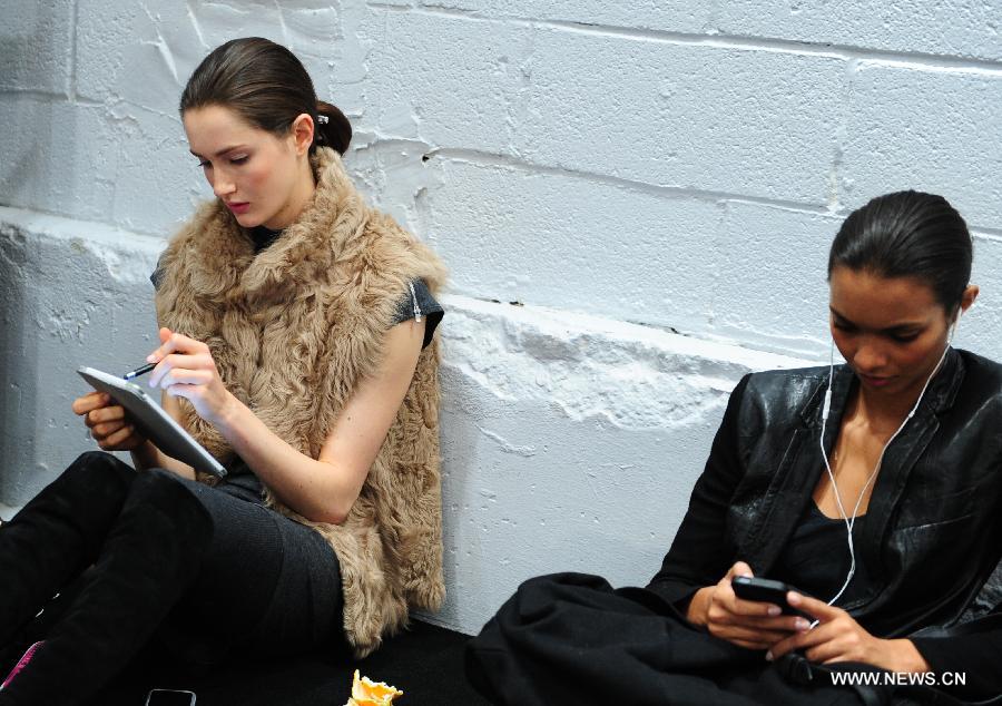 Two models have a rest at the backstage before the presentation of Ralph Lauren 2013 Fall collections of the Mercedes-Benz Fashion Week in New York, Feb. 14, 2013. (Xinhua/Deng Jian)