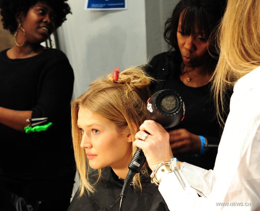 Stylists make hair for a model at the backstage before the presentation of Ralph Lauren 2013 Fall collections of the Mercedes-Benz Fashion Week in New York, Feb. 14, 2013. (Xinhua/Deng Jian)