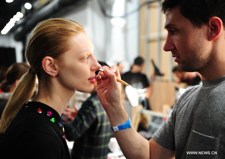 A model gets her makeup done at the backstage before the presentation of Ralph Lauren 2013 Fall collections of the Mercedes-Benz Fashion Week in New York, Feb. 14, 2013. (Xinhua/Deng Jian)