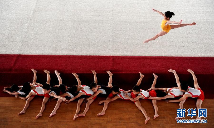 World Press Photo of the Year 2012 has announced the results in Netherland, Feb. 15, 2013, and four Chinese photographers have won awards in the contest. This photo named "Warm up" by Chu Yongzhi has won the 2nd prize of Sports Action. The caption for the photo is "Young male gymnasts stretch their legs as a female gymnast jumps onstage during a warm-up at a youth sports school in Zhejiang Province."（World press photo foundation/Chu Yongzhi）