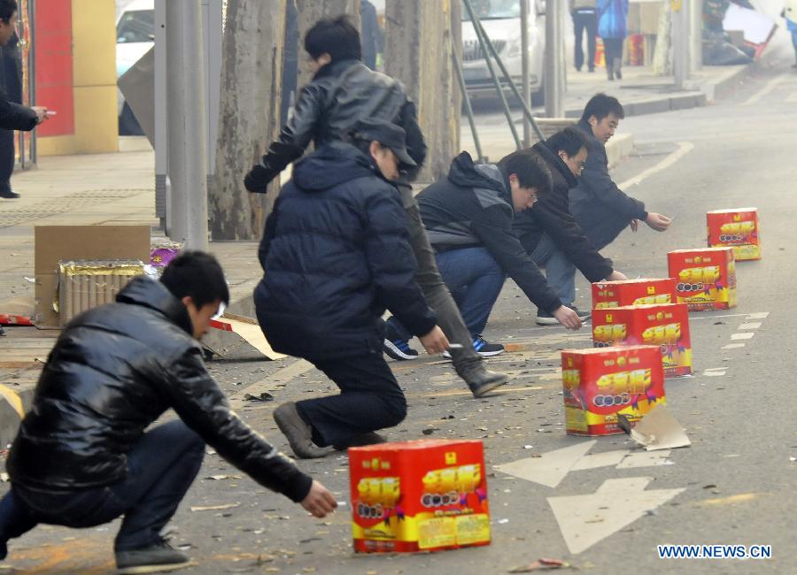 Staff members of some departments set off firecrackers by the road in Dalian, northeast China's Liaoning Province, Feb. 16, 2013. Saturday marks the first working day after the one-week Spring Festival break which started on Feb. 9. Setting off firecrackers on this day is a traditional custom for businessmen to pray for a booming year. (Xinhua/Lv Wenzheng)