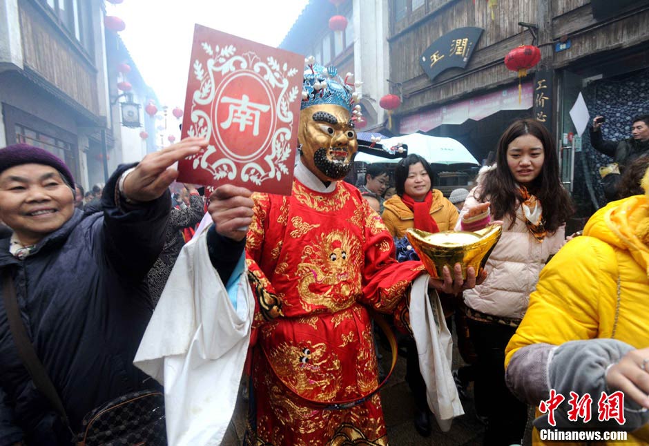 An actor dressed the god of wealth is surrounded by tourists in a folk performance held in Suzhou, Jiangsu Province, Feb. 14, 2013, which is the fifth day of Chinese New Year in 2013 and also the birthday of the god of wealth according to the Chinese folklore. (Chinanews.com/Hang Xingwei)